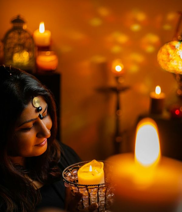 Woman with a calm and focused expression in a softly lit room.
